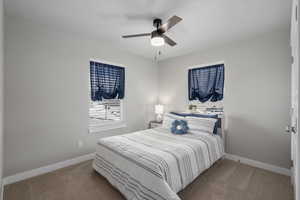 Carpeted bedroom featuring baseboards and ceiling fan