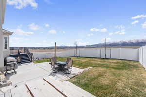 View of yard featuring a mountain view, a patio, a fenced backyard, and stairs