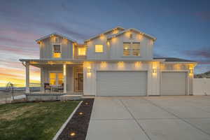 View of front of house with board and batten siding, covered porch, a front yard, an attached garage, and concrete driveway
