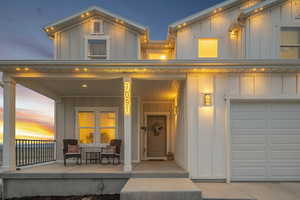 Exterior space with a garage, a porch, and board and batten siding