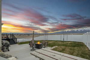 View of patio / terrace with a fenced backyard, grilling area, a deck with mountain view, a fire pit, and stairs