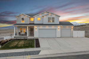 View of front of house featuring concrete driveway, a mountain view, board and batten siding, fence, and covered porch