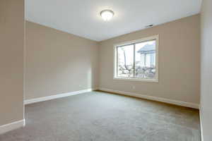 Carpeted spare room with baseboards and visible vents