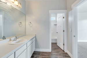 Full bathroom featuring baseboards, shower / washtub combination, vanity, and wood finished floors