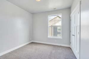 Spare room featuring visible vents, baseboards, and carpet floors