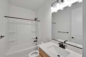 Full bathroom featuring toilet, vanity, and tub / shower combination