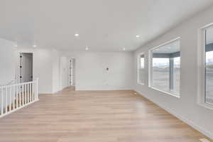 Spare room featuring light wood finished floors, baseboards, and recessed lighting