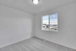 Carpeted empty room featuring baseboards and visible vents