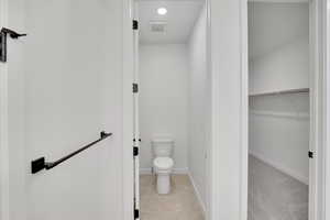 Bathroom featuring tile patterned flooring, visible vents, baseboards, and toilet