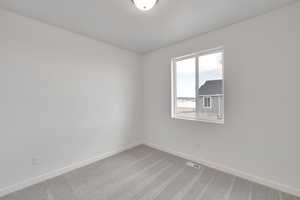 Empty room featuring visible vents, baseboards, and carpet
