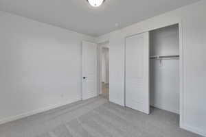 Unfurnished bedroom with a closet, baseboards, and carpet