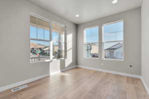 Unfurnished room featuring visible vents, baseboards, recessed lighting, and wood finished floors