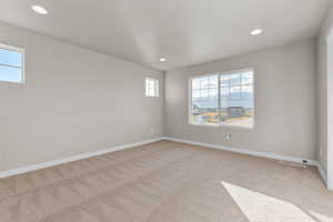 Spare room with baseboards, recessed lighting, and light carpet