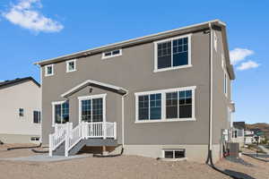 Rear view of property with central AC and stucco siding