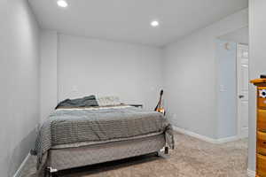 Carpeted bedroom with recessed lighting and baseboards