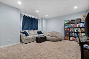 Living room with carpet flooring, baseboards, and recessed lighting