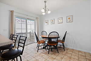 Dining room with baseboards, stone finish floor, and an inviting chandelier