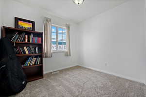 Carpeted spare room with visible vents and baseboards
