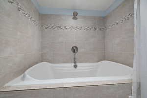 Bathroom featuring tiled tub, tile walls, and a tile shower