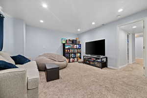 Carpeted living room featuring recessed lighting, visible vents, and baseboards