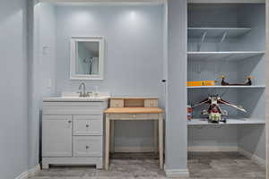 Bathroom with vanity, baseboards, and wood finished floors