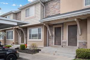 Entrance to property with stone siding and stucco siding
