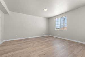 Spare room featuring baseboards and light wood finished floors