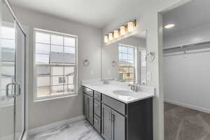 Full bathroom featuring a sink, baseboards, and a healthy amount of sunlight