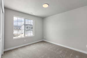 Carpeted empty room featuring visible vents, baseboards, and a textured ceiling