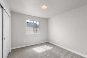 Unfurnished bedroom featuring a closet, carpet flooring, baseboards, and visible vents