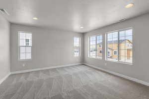 Spare room featuring light colored carpet, baseboards, visible vents, and recessed lighting