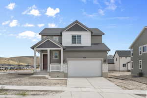 View of front of home with a shingled roof, stone siding, a garage, cooling unit, and driveway