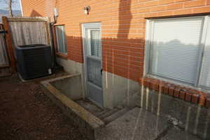 Exterior basement entrance and central air unit