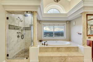 Full bath with a bath, decorative columns, plenty of natural light, and a shower stall