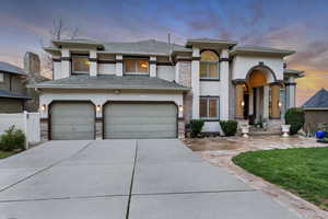 Prairie-style house with concrete driveway, an attached garage, fence, and stucco siding