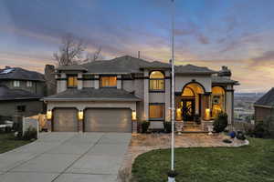 View of front of home featuring driveway, stucco siding, fence, and a front lawn