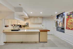 Kitchen featuring concrete floors, recessed lighting, a peninsula, and butcher block countertops