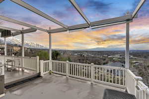 Patio terrace at dusk with a mountain view and glass enclosure