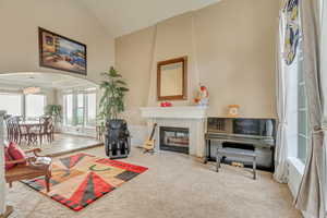 Living room with arched walkways, carpet flooring, vaulted ceiling, and a premium fireplace