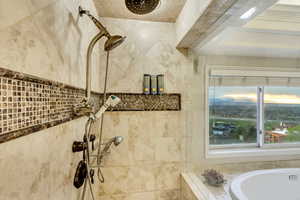Full bathroom featuring a bath and a tile shower