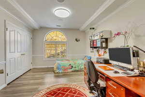 Office featuring crown molding, wood finished floors, baseboards, and visible vents