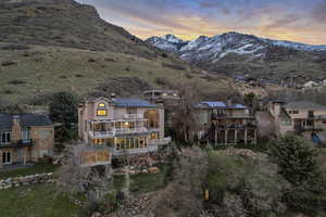 Rear view of house featuring solar panels, a balcony, a chimney, a mountain view, and a residential view