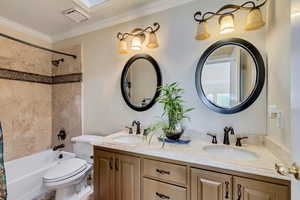 Bathroom with a sink, visible vents, toilet, and ornamental molding