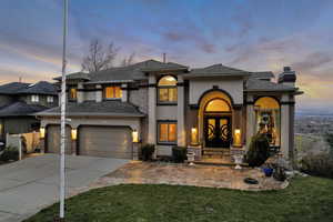 View of front facade with a front yard, an attached garage, a chimney, concrete driveway, and stucco siding