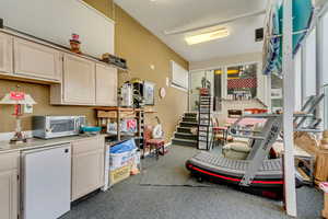 Garage featuring fridge, a toaster, and baseboards