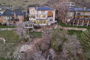 Rear view of house with a sunroom, roof mounted solar panels, stucco siding, and a balcony