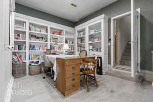 Office featuring visible vents, built in study area, and light wood-style floors