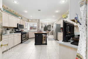 Kitchen featuring light tile patterned floors, light countertops, appliances with stainless steel finishes, and visible vents