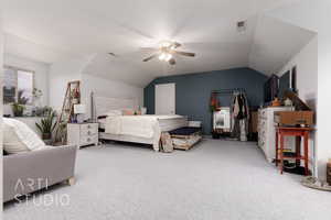 Carpeted bedroom with visible vents, ceiling fan, and vaulted ceiling