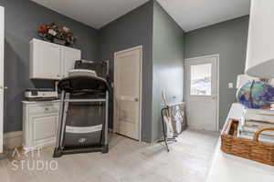 Clothes washing area with light wood-type flooring